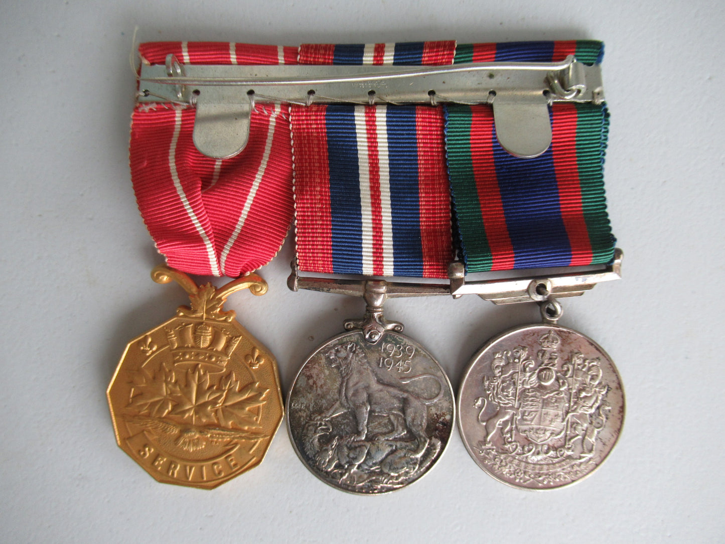 CANADA GROUP OF 3 WWII MEDALS ON MEDAL BAR. NAMED TO CPL. J.G. McCAFFREY. IN ORIGINAL CASE.