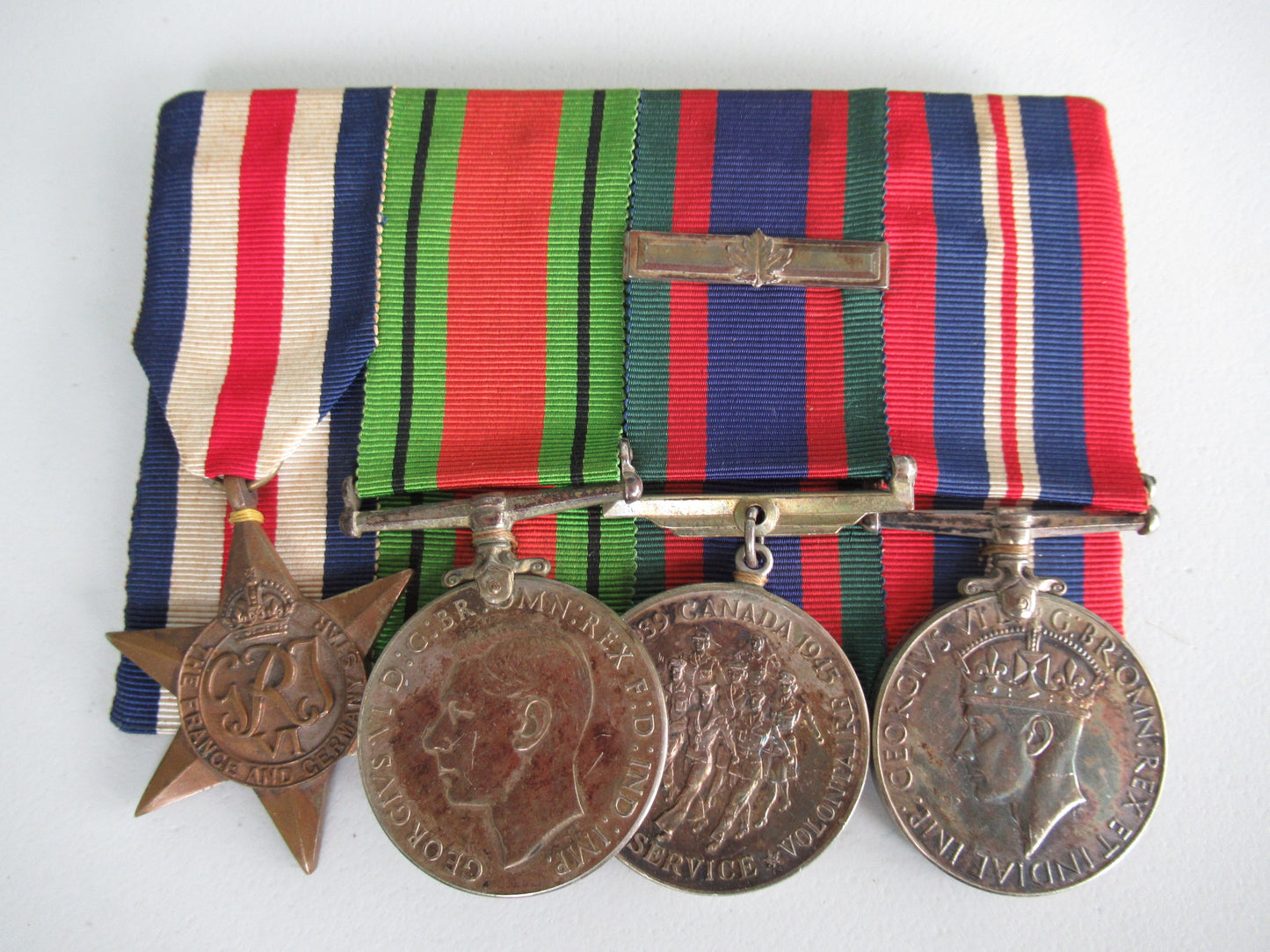 CANADA GROUP OF 4 WWII MEDALS ON MEDAL BAR. NOT NAMED.  COMES WITH GROUP OF 4 MATCHING MINIATURE MEDALS ON MEDAL BAR. 3.